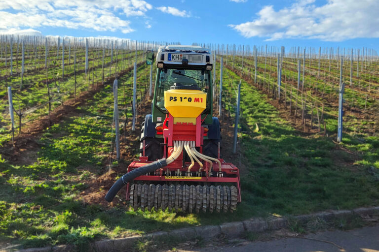 Foto eines Traktors beim Einsäen einer Unterstockbegrünung im Weinberg